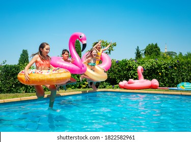 Many of children with inflatable toys donut run and dive in the water pool smiling happily spending vacations - Powered by Shutterstock