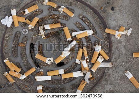 Many cigarette butts discarded on a drain
