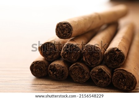 Many cigars on wooden table, closeup view