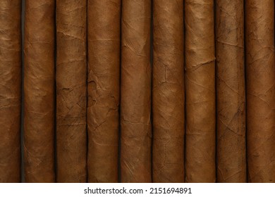 Many Cigars Wrapped In Tobacco Leaves As Background, Top View