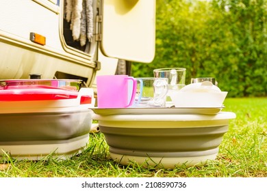 Many Clean Dishes Drying Outdoor Against Camper Vehicle. Washing Up On Fresh Air. Camping On Nature, Dishwashing Outside.