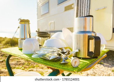 Many clean dishes outdoor on dish drying mat against camper vehicle. Washing up on fresh air. Camping on nature, dishwashing outside. Longing for an rv dishwasher. - Shutterstock ID 1785124001