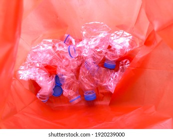 Many Clear Crumpled Bottle With Blue Cap In Orange Color Garbage Bag For Recycle Waste Collected In Japan. Every House Must Separate Waste Before Throw Away.Garbage Classification Concept.