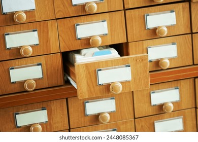 Many closed wooden boxes and one open analog paper file cabinet. Unsigned. Archival repository of information and data Place for inscription - mockup. Photo. Selective focusing. Natural lighting