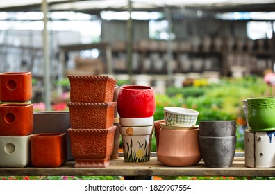 Many colored pots pots in a gardening store. Decorative plastic flowerpots. Recycling plastic. Production of plastic utensils for gardening