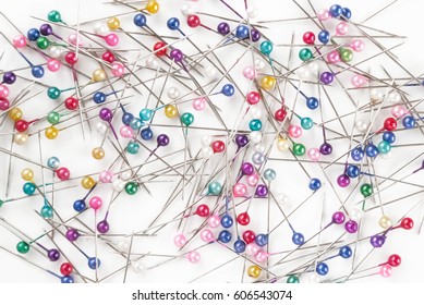 many colored sewing pins on white background