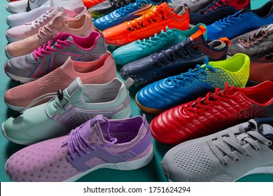 many colored sports shoes, sneakers and football boots, stand in a row, side location