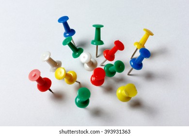 Many colored thumbtacks stuck into a white sheet of paper - Shutterstock ID 393931363