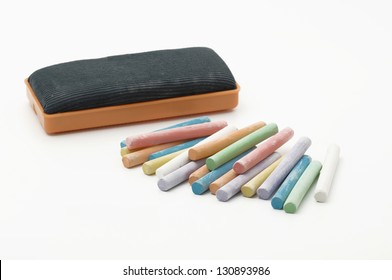 Many colorful chalks and a eraser isolated on white background