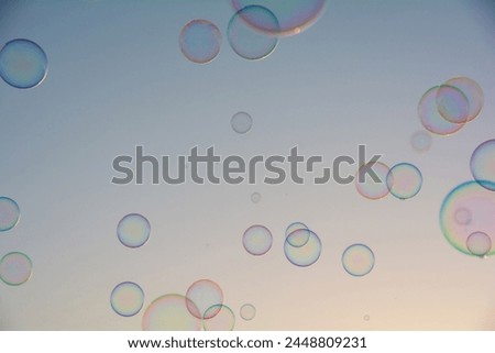 Many colorful soap bubbles float in the sky