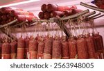 Many delicious sausages hanging on a store counter