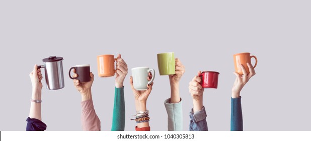 Многие различные руки подняли вверх, держа кофе чашку