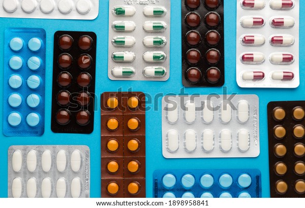 Many\
different blisters pills on blue\
background