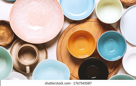 Many Different Ceramic Plates And Bowls On A Light Background, Top View.  Different Tableware. Empty Colorful Plates Flat Lay