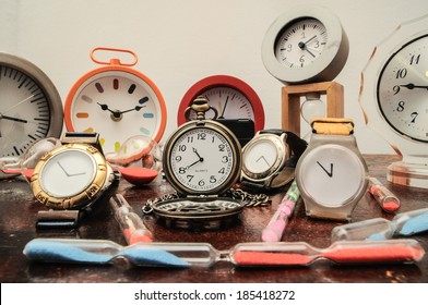 Many Different Clocks On A Woden Table