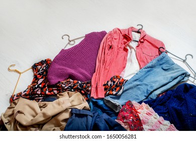 Many different clothes on shoulders  lie on a white floor. - Shutterstock ID 1650056281