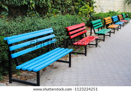 Many different color (red, blue, green, yellow) empty wooden benches in the park for romantic rest during walk, Sliema, Malta, Europe