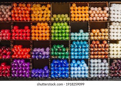 Many different colored candles on a shelf