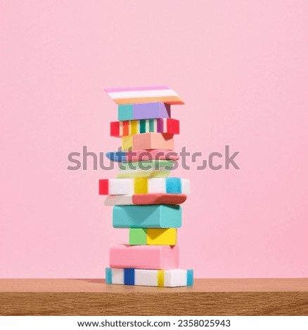 Many different colored erasers on a pink background. School supplies composition.