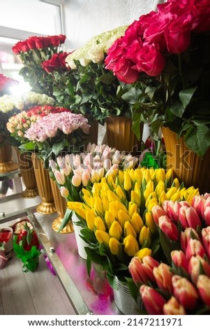Many different colors on the stand table in the flower shop. Showcase. Background of mix of flowers. Beautiful flowers for catalog or online store. Floral shop and delivery concept.