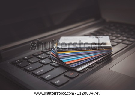 Many different credit cards on computer keyboard. The use of online services for payment of goods and services via the Internet. Payroll and a discount card for purchases in online stores.