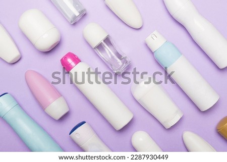 Many different deodorants on color background, top view