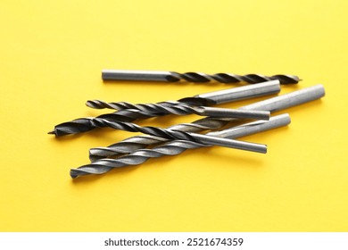 Many different drill bits on yellow background