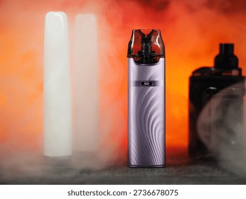 many different electronic cigarettes on a smoky background. Disposable and refillable smoking devices