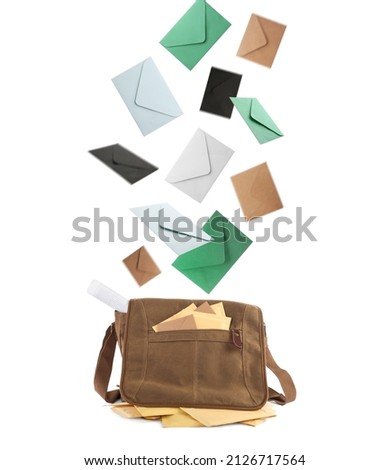 Many different envelopes falling into brown postman's bag on white background