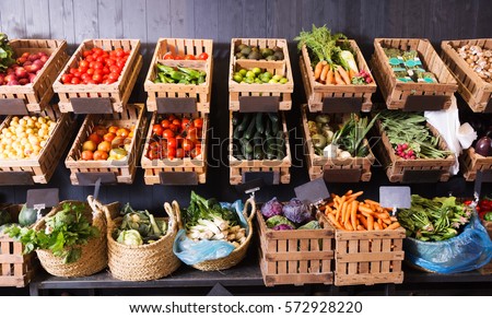 many different fresh fruits and vegetables in baskets on food market