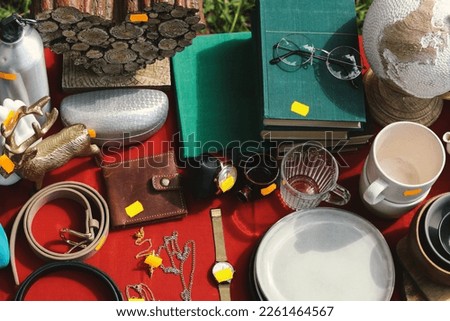 Many different items on table outdoors, above view. Garage sale