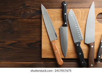 Many different knives and board on wooden table, top view. Space for text - Powered by Shutterstock