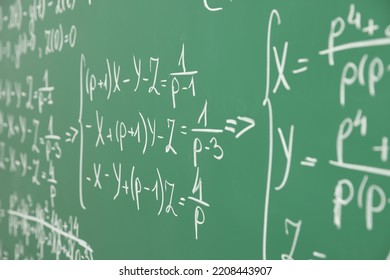 Many different math formulas written on chalkboard, closeup