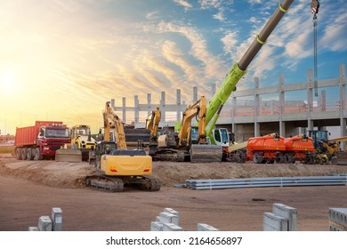 Many different multiclored colorful heavy industrial machinery equipment at construction site parking area against warehouse building city infrastructure development  Commercial vehicles rental sale
