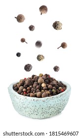 Many Different Peppercorns Falling Into Bowl On White Background