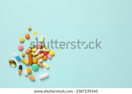 Many different pills on light blue background, flat lay. Space for text