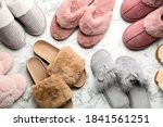Many different soft slippers on white marble background, flat lay