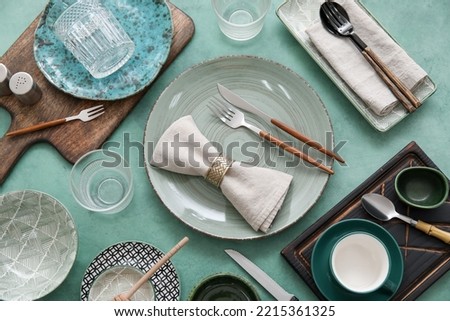 Many different tableware on green background, top view