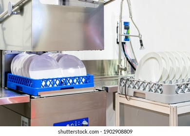 many dish or white plate arranged on basket for cleaning by automatic dishwasher machine in kitchen room restaurant