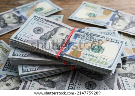 Many dollar banknotes on wooden table, closeup. American national currency