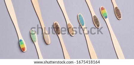 Many eco toothbrash at table. Different color bamboo tooth brush for morning hygiene routine. Diagonal photo up view. Flat lay soft shadow