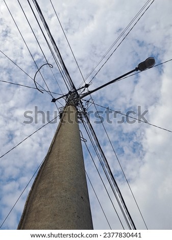 Many electrical cables on poles are on the side of the road