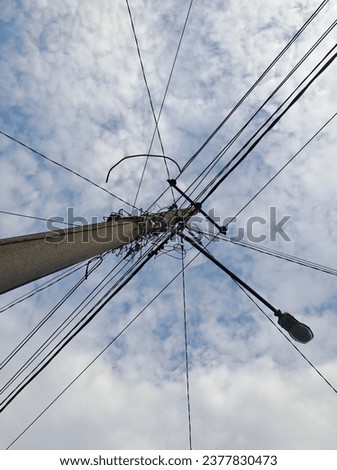 Many electrical cables on poles are on the side of the road