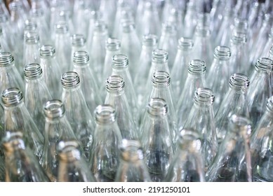 Many Empty Bottles On The Bottling Line, Factory Worker Working In Production Line At Beverages Factory, Packaging Warehouse And Processing Facility