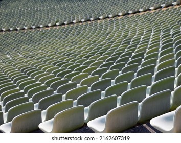many empty green seats in the stands of the empty stadium with no people waiting for the event to begin