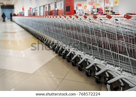 Many empty shopping carts in a row. Inside a large supermarket. Modern and stylish shopping Mall. Grocery store
