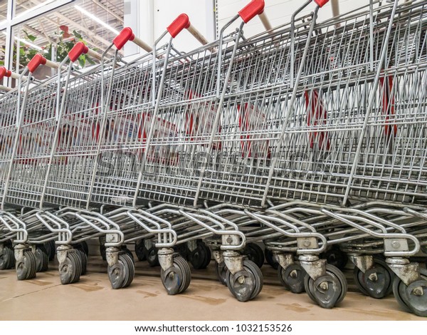 Many empty\
shopping carts in a row. Inside a large supermarket. Modern and\
stylish shopping Mall. Grocery\
store