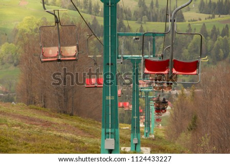 Many empty ski lift chairs in a row close up in the summer