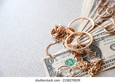 Many expensive golden jewerly rings, earrings and necklaces with big amount of US dollar bills with copy space. Pawnshop or jewerly shop concept