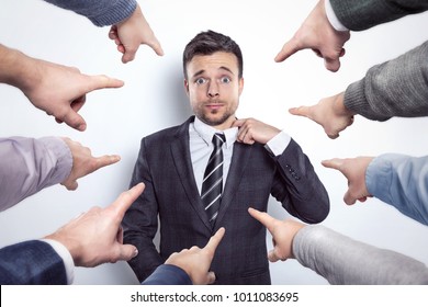 Many Fingers Pointing At A Businessman